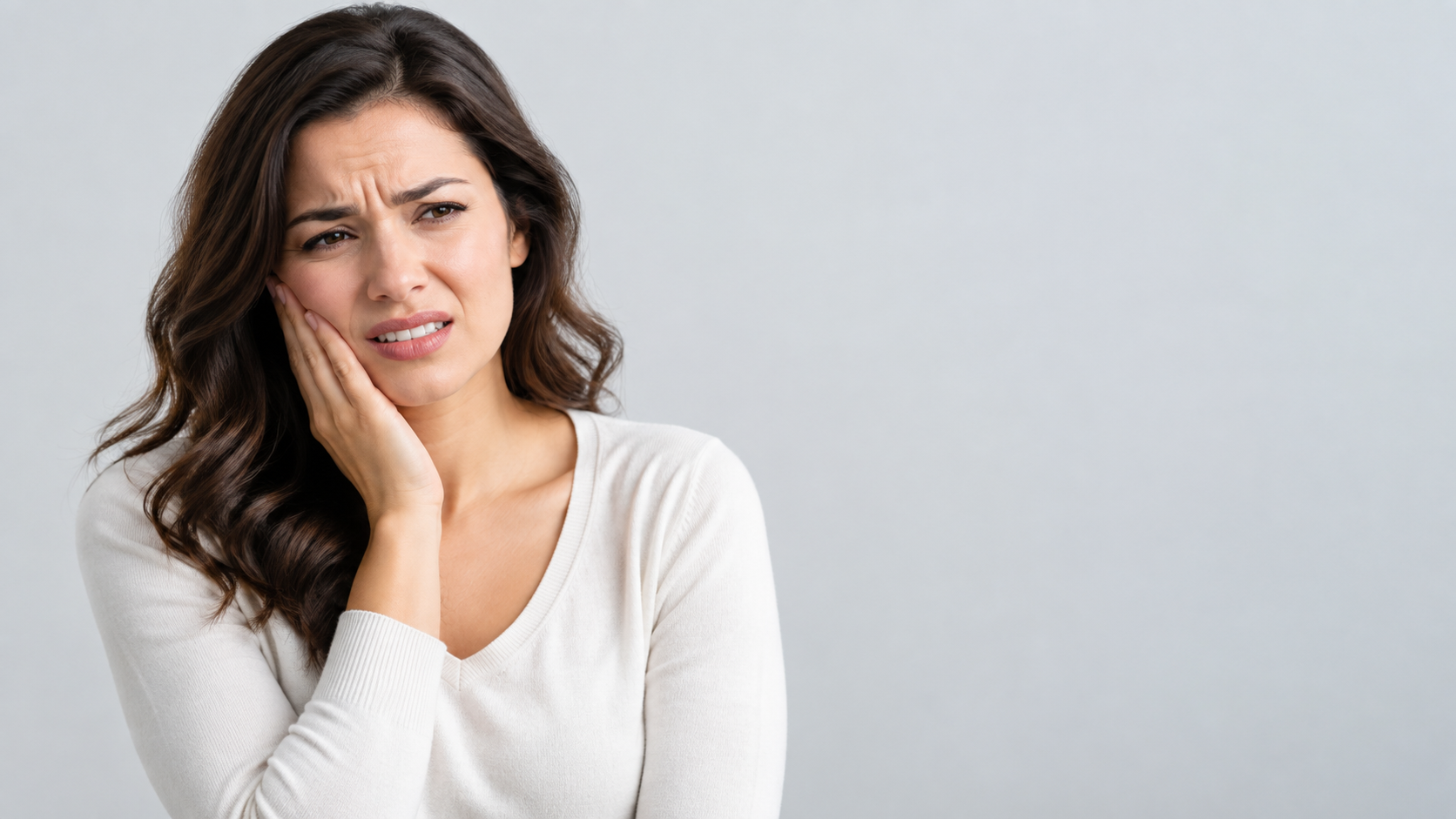 Woman holding her jaw in pain from a severe toothache
